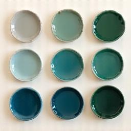 Array of ceramic glaze swatches in earthy and deep lake tones, such as Riverstone Grey, Deep Lake Blue, and Moss Green.