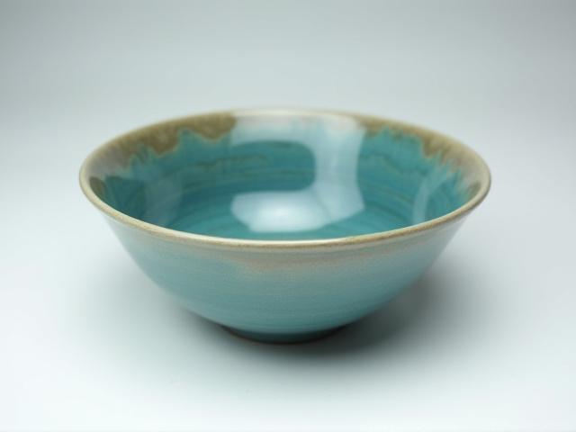 Deep ceramic bowl with a swirling blue-green riverbed glaze, perfect for camp chili.